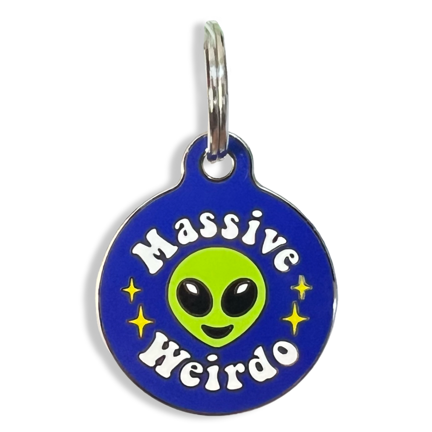 A unique dog tag designed with an alien motif, inscribed with the words "massive weirdo."